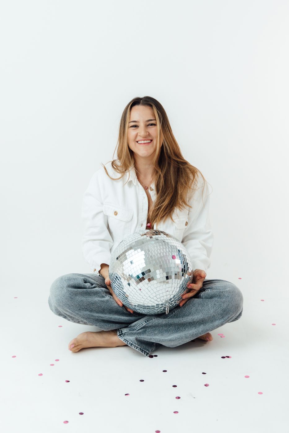 The photographer of Tropical Weddings CR smiling, holding a disco ball