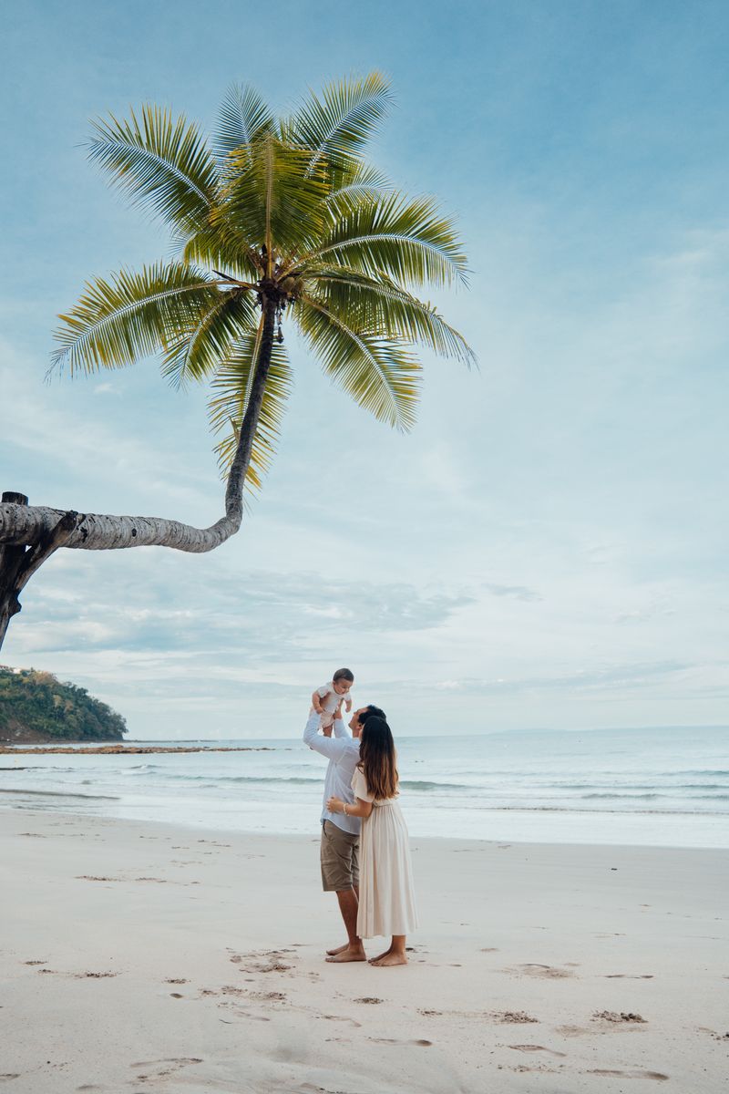 Family on the beach under a palm tree