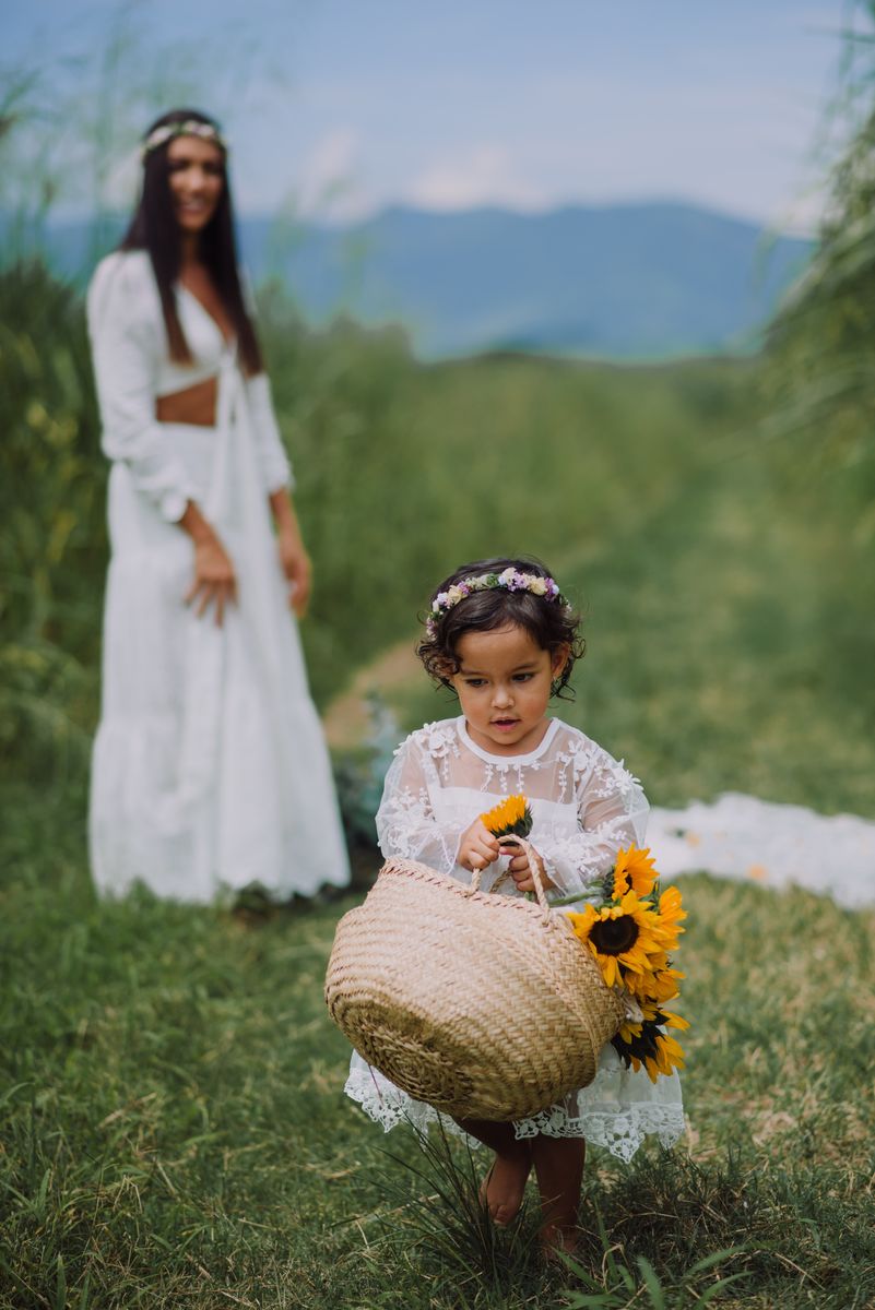 Mother and daughter with sunflowers in a green field